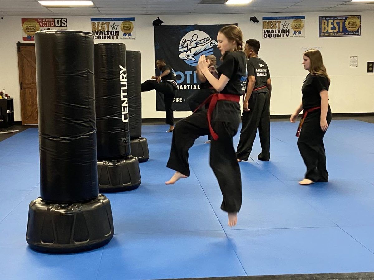 Teen students practicing kicks on the bags at Motivate